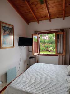 a bedroom with a bed and a window at Casa Bordó, B & B in Tandil
