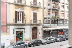 een groep auto's geparkeerd voor een gebouw bij Home Principe Amedeo 184 in Bari