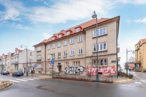 a building with graffiti on the side of a street at CityRooms Sopot in Sopot