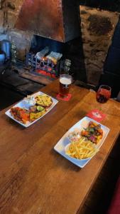 two plates of food and a glass of beer on a wooden table at The Dante arms in Middleham