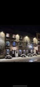 a large stone building with picnic tables in front of it at The Dante arms in Middleham