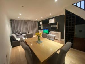 a living room with a wooden table and chairs at Standard Villa in London