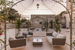 un patio al aire libre con sofás y techo de cristal en Masseria Torrelonga, en Fasano
