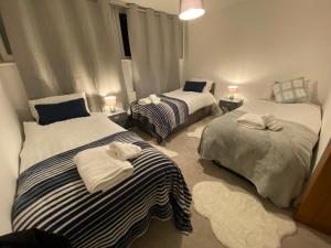 a bedroom with two beds with towels on them at Standard Villa in London