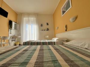 una camera d'albergo con due letti e una finestra di Hotel Parini a Cesano Boscone