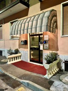 a building with an awning with two potted plants in front at Hotel Parini in Cesano Boscone