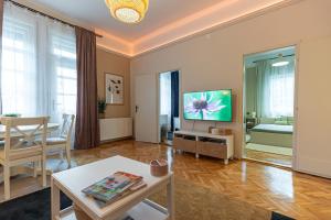 a living room with a television and a table at BB Görgey Apartman I. in Miskolc