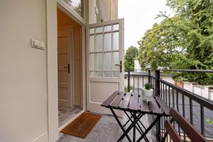 a porch with a wooden table and a door at BB Görgey Apartman I. in Miskolc