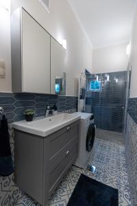 a bathroom with a sink and a washing machine at BB Görgey Apartman I. in Miskolc
