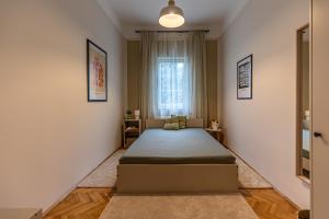 a bedroom with a bed in the corner of a room at BB Görgey Apartman I. in Miskolc