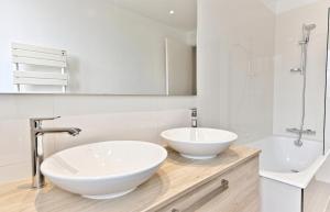 een badkamer met 2 wastafels, een bad en een spiegel bij Appartement luxueux Porte Maillot - Neuilly -II in Neuilly-sur-Seine