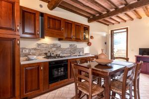 a kitchen with wooden cabinets and a table with chairs at Podere Cascatelle&Agriletizia - Cascate Naturali in Massa Marittima