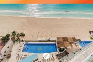 an overhead view of a beach with a swimming pool and the ocean at The Oceanfront by Casa Paraiso in Cancún