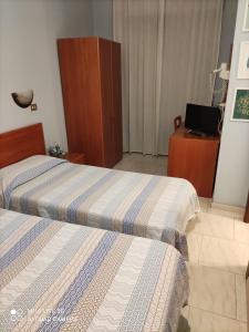 ein Hotelzimmer mit 2 Betten und einem Schreibtisch in der Unterkunft HOSTAL D'ANNUNZIO HOUSe in Cesano Boscone