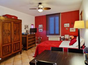 ボローニャにあるCa di Valeの赤い壁のベッドルーム1室(ベッド1台、テーブル付)
