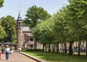 een groep mensen die op een pad voor een gebouw lopen bij Boshuis 29 Oisterwijk nabij Efteling en Beekse Bergen in Oisterwijk