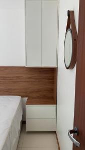 a small bedroom with a bed and a mirror at Solaris Village Imbassaí in Imbassai