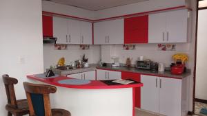 a kitchen with white cabinets and a red counter top at Cabaña el Rincon Del Lago in Paipa
