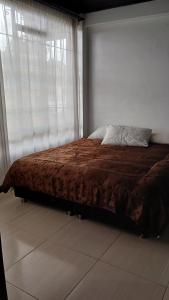 a bed in a bedroom with a large window at Cabaña el Rincon Del Lago in Paipa