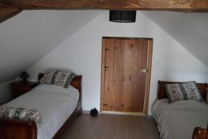 um quarto com 2 camas e uma porta de madeira em Gîte Aliénor en Anjou em Vernoil