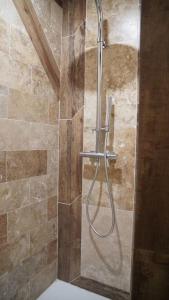 um chuveiro com uma mangueira na casa de banho em Gîte Aliénor en Anjou em Vernoil