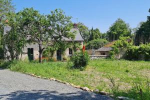 uma casa velha na berma de uma estrada em Gîte Aliénor en Anjou em Vernoil