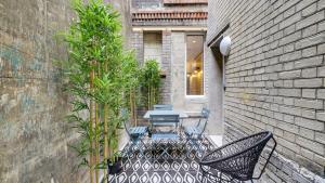 a patio with a table and chairs and a brick wall at 154 Suite Phil - Superb apartment in Paris in Paris