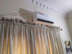 um quarto com cortina e ar condicionado em St Theresers apartments lodge4 em Lagos