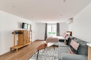 a living room with a couch and a bed at 136 Suite Harold - Superbe Appartement à Paris. in Paris