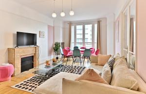 sala de estar con sofá y chimenea en Appartement Luxueux Porte Maillot - Neuilly, en Neuilly-sur-Seine