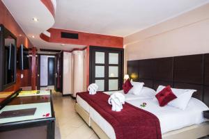 una camera con due letti con cuscini rossi e bianchi di Anezi Tower Hotel ad Agadir