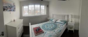 a white bedroom with a bed and a window at Hidden beauty in peaceful place in Peterlee
