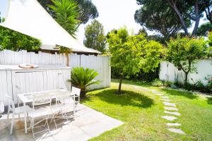 a backyard with a white fence and a table and chairs at Roma Casal Palocco - Casa dell'artista in Casal Palocco