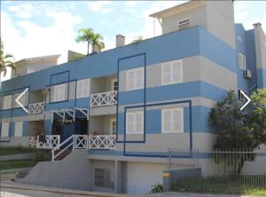 ein blau-weißes Apartmenthaus mit einer Treppe in der Unterkunft Edificio Daniela Ap 102 in Bombinhas