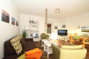 ein Wohnzimmer mit einem Sofa und einem Tisch in der Unterkunft Ahrendt- Haus Cäcilia  in Wenningstedt-Braderup