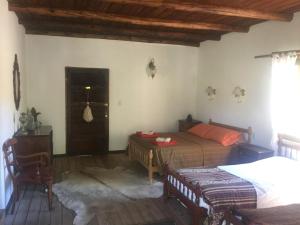 a bedroom with two beds and a table at Estancia Santa Thelma in Gobernador Gregores