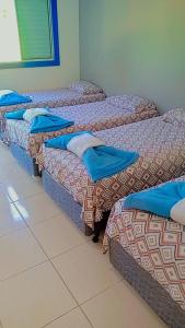 a row of three beds in a room at Pousada restaurante recanto do Marimar in Paraty