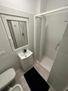 a white bathroom with a sink and a shower at Langolo di laura borgo roma destiny home 3 in Verona