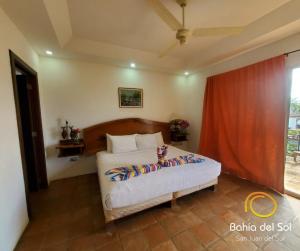 1 dormitorio con cama y cortina roja en Bahia Del Sol Villas & Condominiums en San Juan del Sur