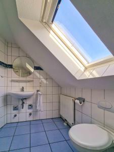 a bathroom with a toilet and a skylight at Abendrot in Greetsiel