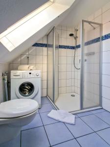 a bathroom with a shower and a toilet and a washing machine at Abendrot in Greetsiel