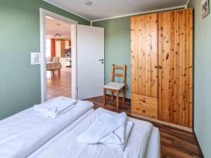 a bedroom with a bed and a chair and a door at Abendrot in Greetsiel