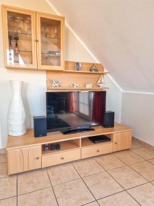 a wooden entertainment center with a television on it at Abendrot in Greetsiel