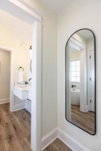 a bathroom with a mirror and a sink at The Princess Anne 200 Inn at Old Beach in Virginia Beach +29 photos