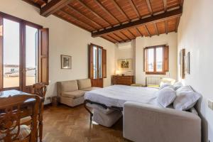 um quarto com uma cama grande e um sofá em Palazzo Cecchi Luxury Apartment em Florença