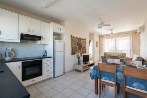 a kitchen and living room with a refrigerator and a table at Royal Seacrest in Paphos City