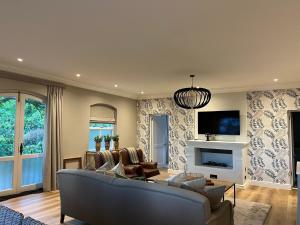 a living room with a couch and a tv at Luxury Constantia Apartment in Cape Town
