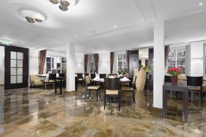 シュリースハイムにあるTRIP INN Kaiser Hotel & Restaurant Heidelberg-Schriesheimのテーブルと椅子と窓のあるダイニングルーム