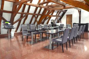 シュリースハイムにあるTRIP INN Kaiser Hotel & Restaurant Heidelberg-Schriesheimのテーブルと椅子のあるダイニングルーム