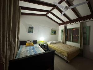 - une chambre avec 2 lits et un ventilateur de plafond dans l'établissement Villas La Paillote Costa Rica, à Puntarenas